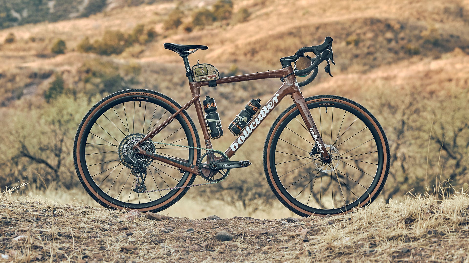 Drop bar gravel bike standing up beside gravel road with Teravail wheels and tires